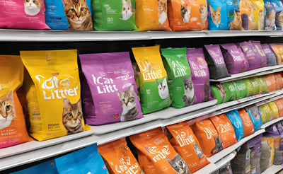 Shelves with colorful cat litter bags featuring various cat images and brand logos