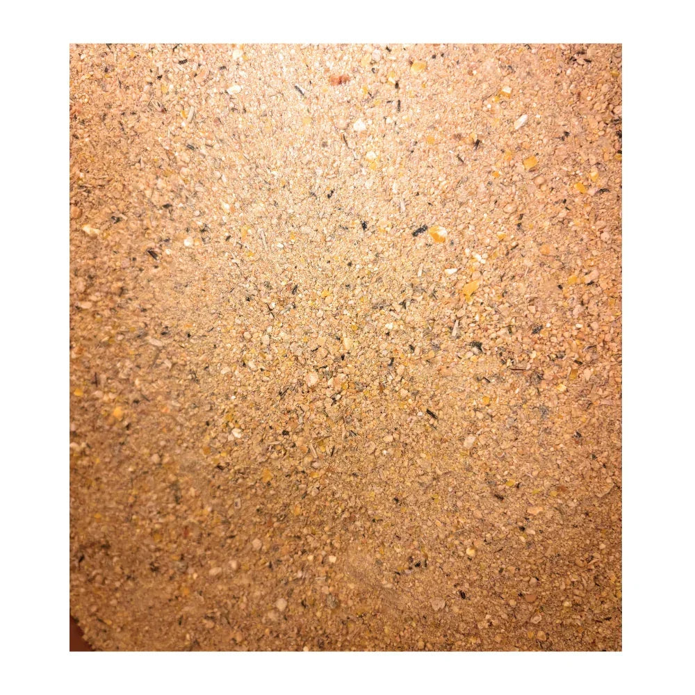 Close-up of finely ground animal feed with mixed grains and seeds texture