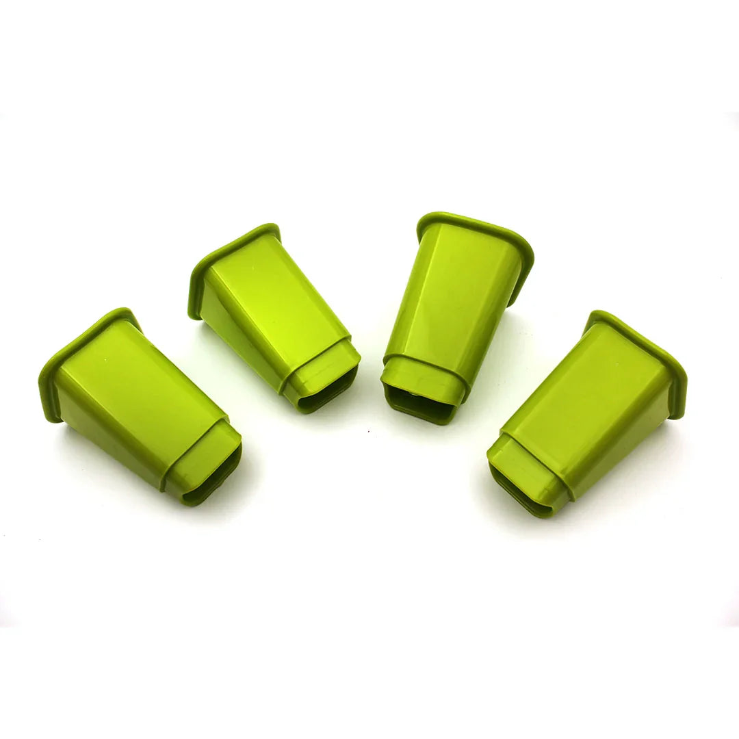 Set of four green plastic furniture leg covers isolated on white background