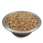 Metal bowl filled with mixed seeds for parakeets, including millet and colorful grains