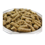 Close-up of a white bowl filled with brown cylindrical animal feed pellets on white background