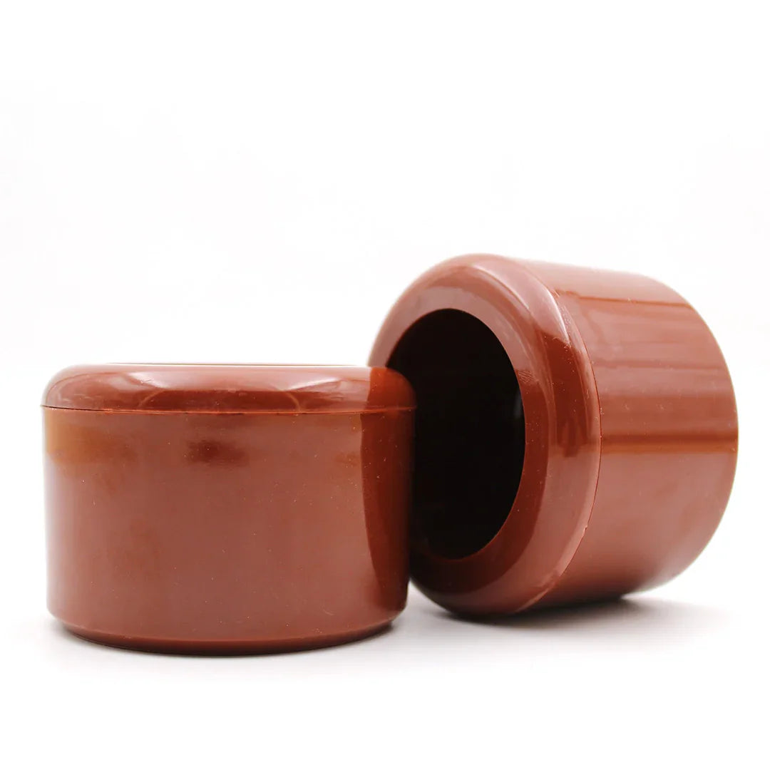 Brown plastic pigeon grit feeders with removable lids on white background