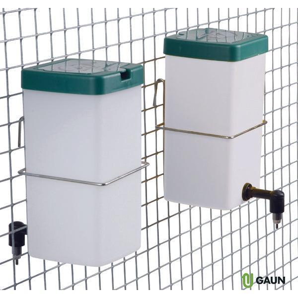 Two white plastic rabbit water feeders with green lids mounted on wire cage wall, metal holders, and one equipped with a drinking nozzle