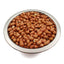 Raw peanuts with skin in a stainless steel bowl on white background