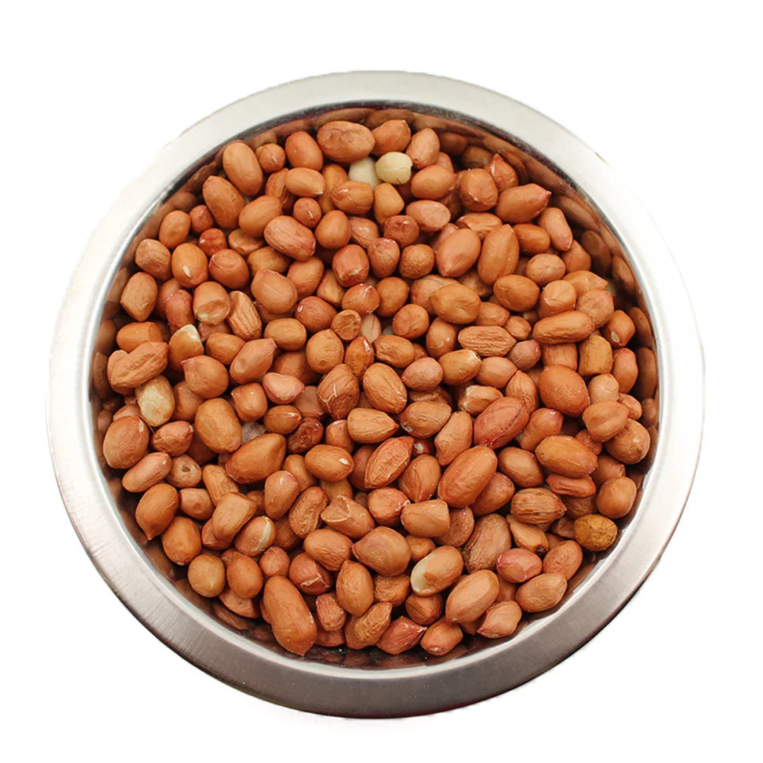 Metal bowl filled with raw peanuts for bird feeding on a white background