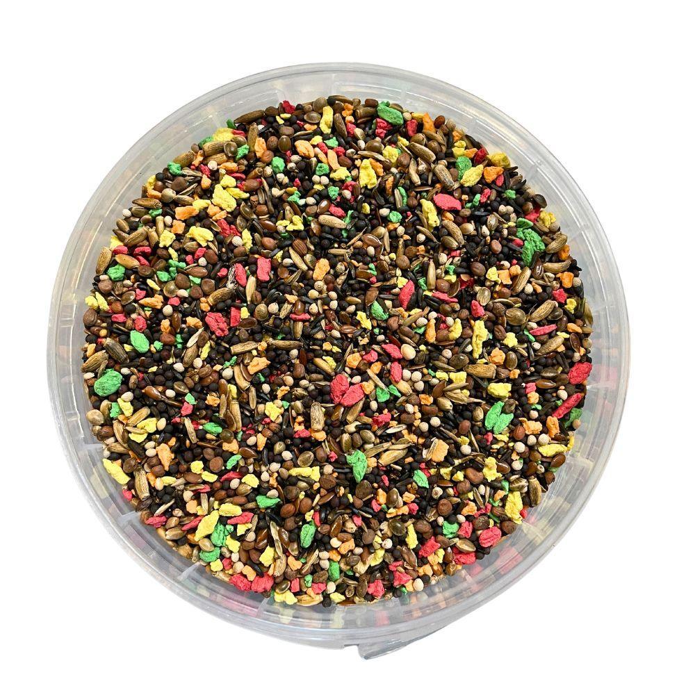 Colorful mixed bird seed blend in a clear plastic container for stimulating bird singing