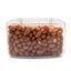 Clear plastic container filled with whole raw peanuts with skin against white background