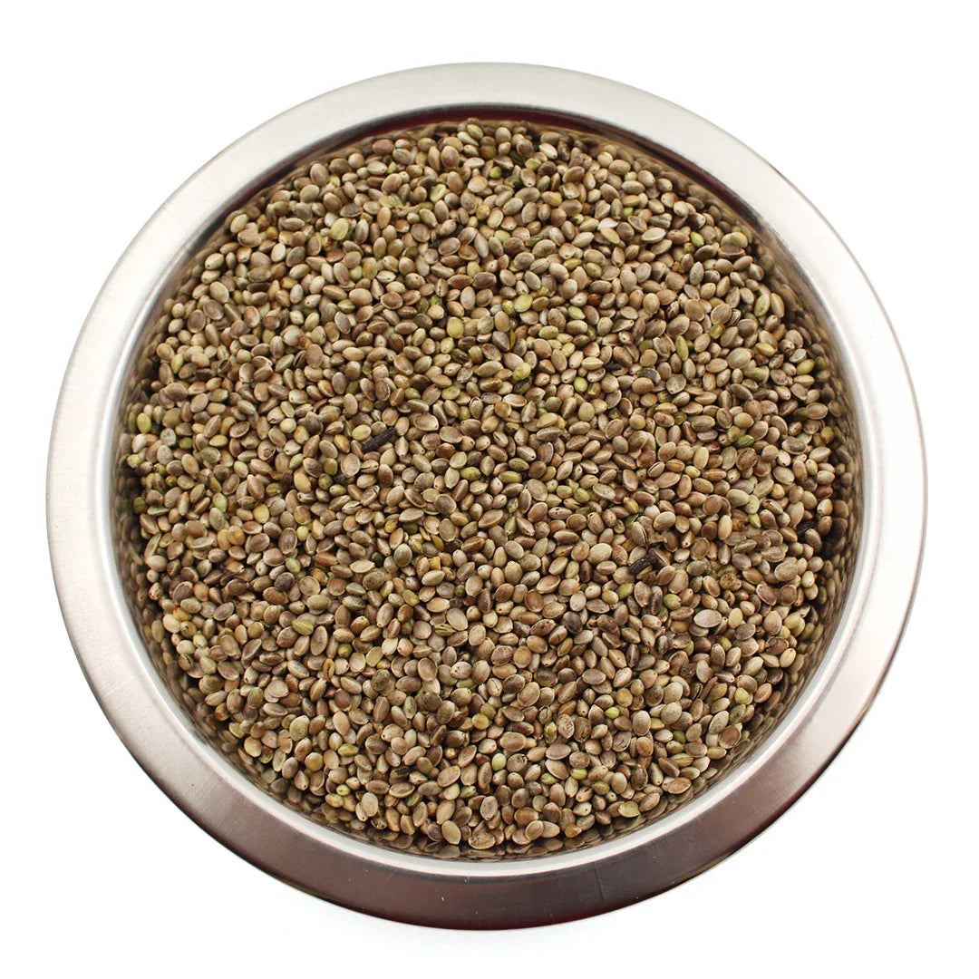 Metal bowl filled with small brown and green bird seeds for bird feeding