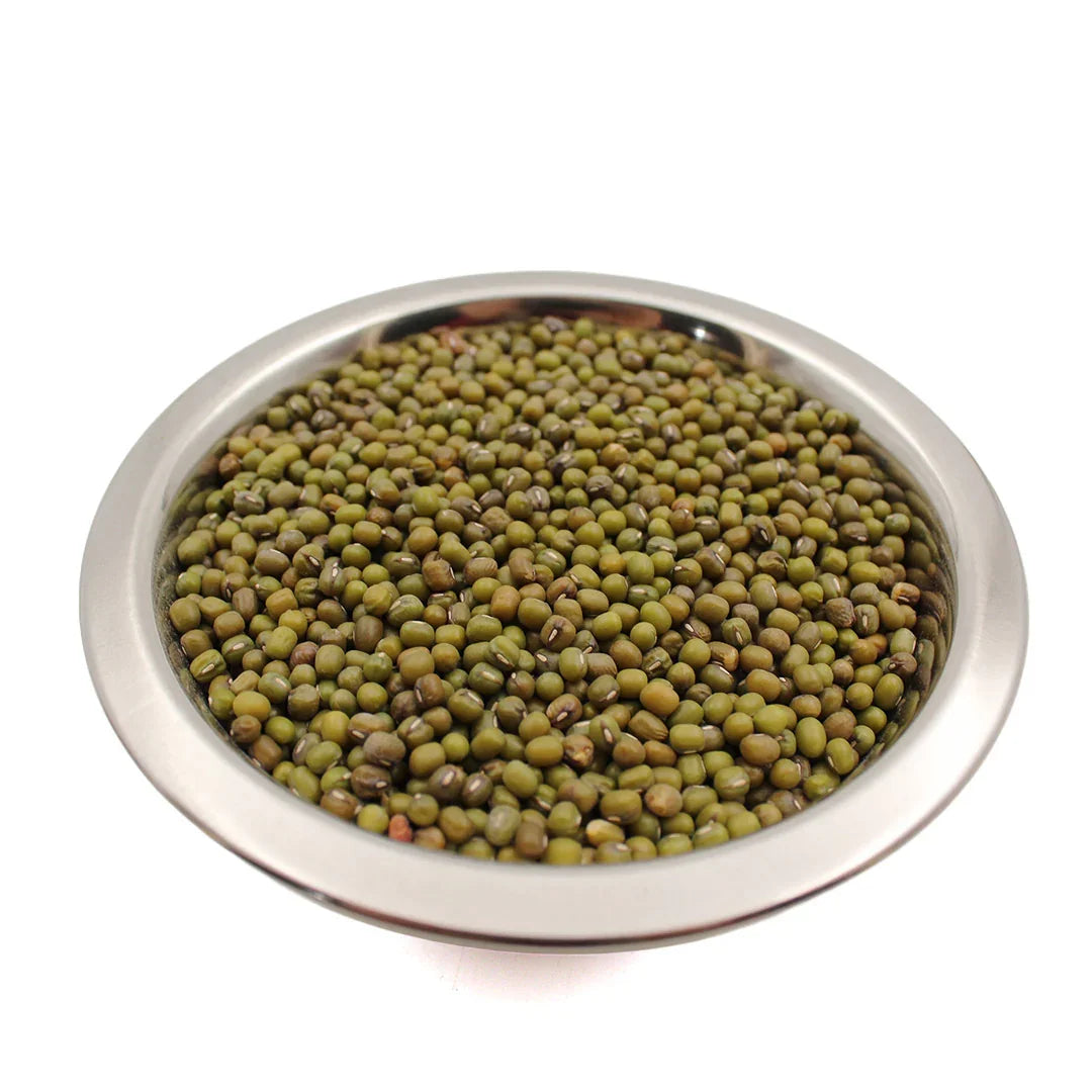 Close-up of green mung beans in a round stainless steel bowl on white background