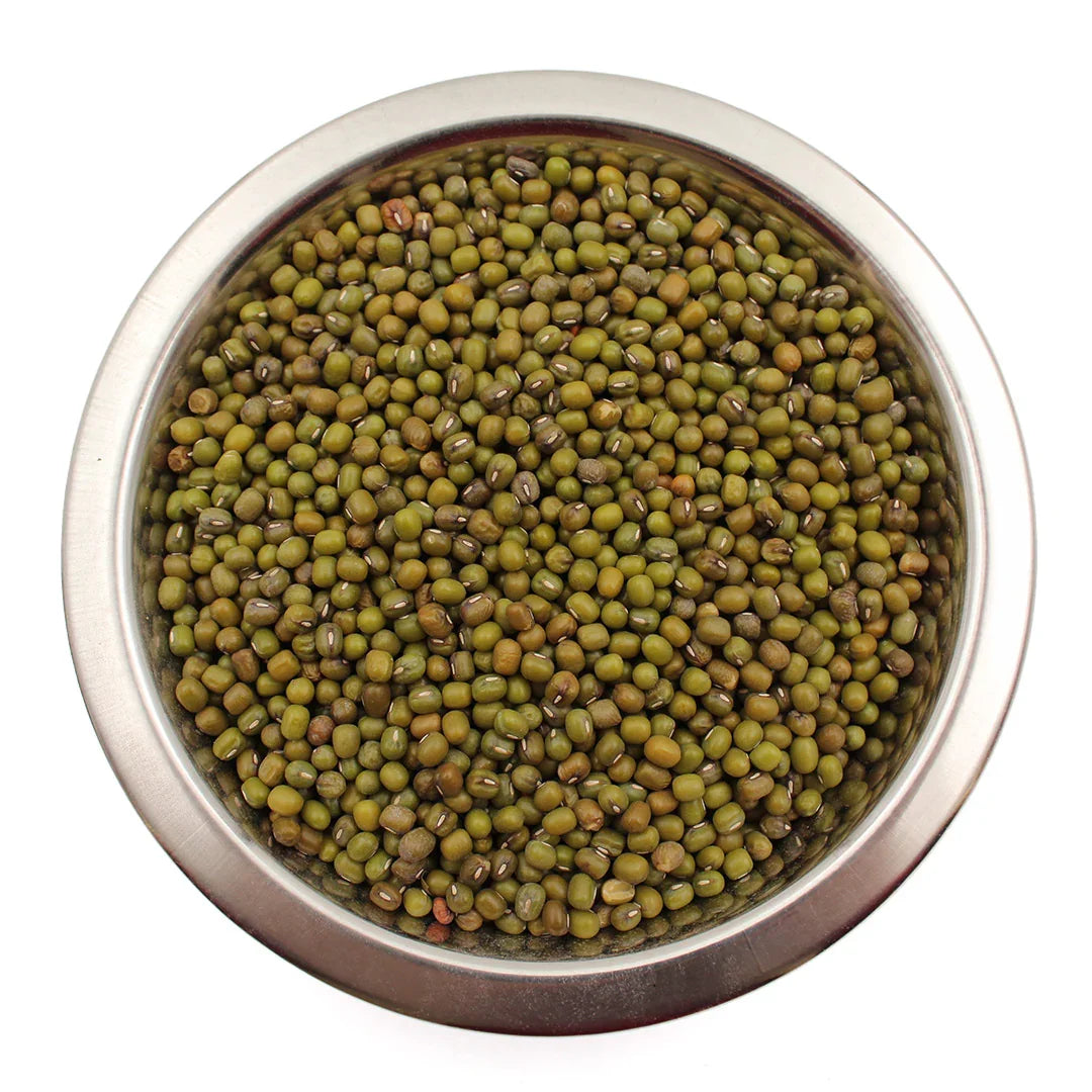 Stainless steel bowl filled with green mung beans on white background