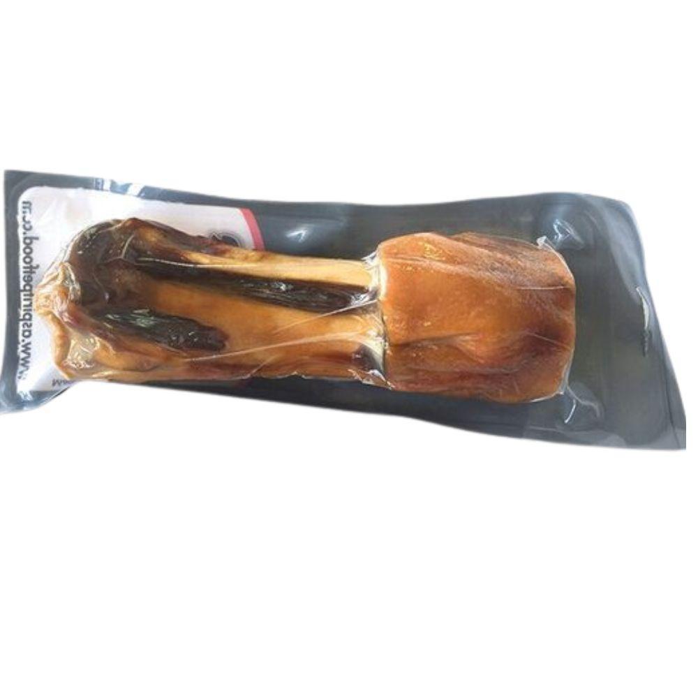 Vacuum-sealed ham bone dog chew treat in black packaging on white background