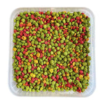 Colorful green, red, and orange bird pellets in a transparent square container for cockatiels and lovebirds