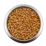 Metal bowl filled with yellow popcorn kernels on white background