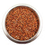 Metal bowl filled with reddish-brown sorghum bird seeds on white background