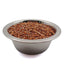 Metal bowl filled with small brown sorghum grains on white background